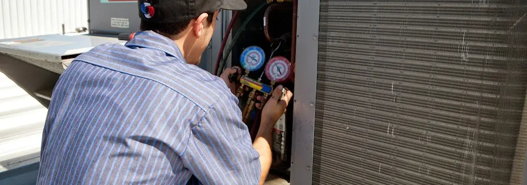 HVAC technician servicing a condenser unit in Jonesborough